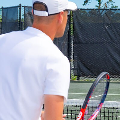 man playing tennis at New Seabury tennis court